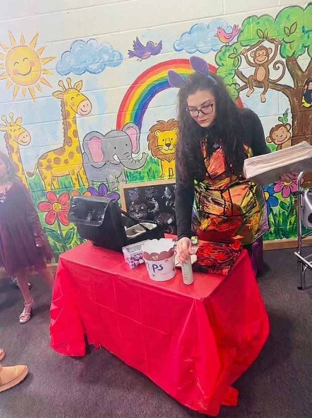 Tiffany Dinehart offering Bloom and Brush face painting services at a children's party